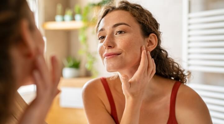 woman looking at her skin